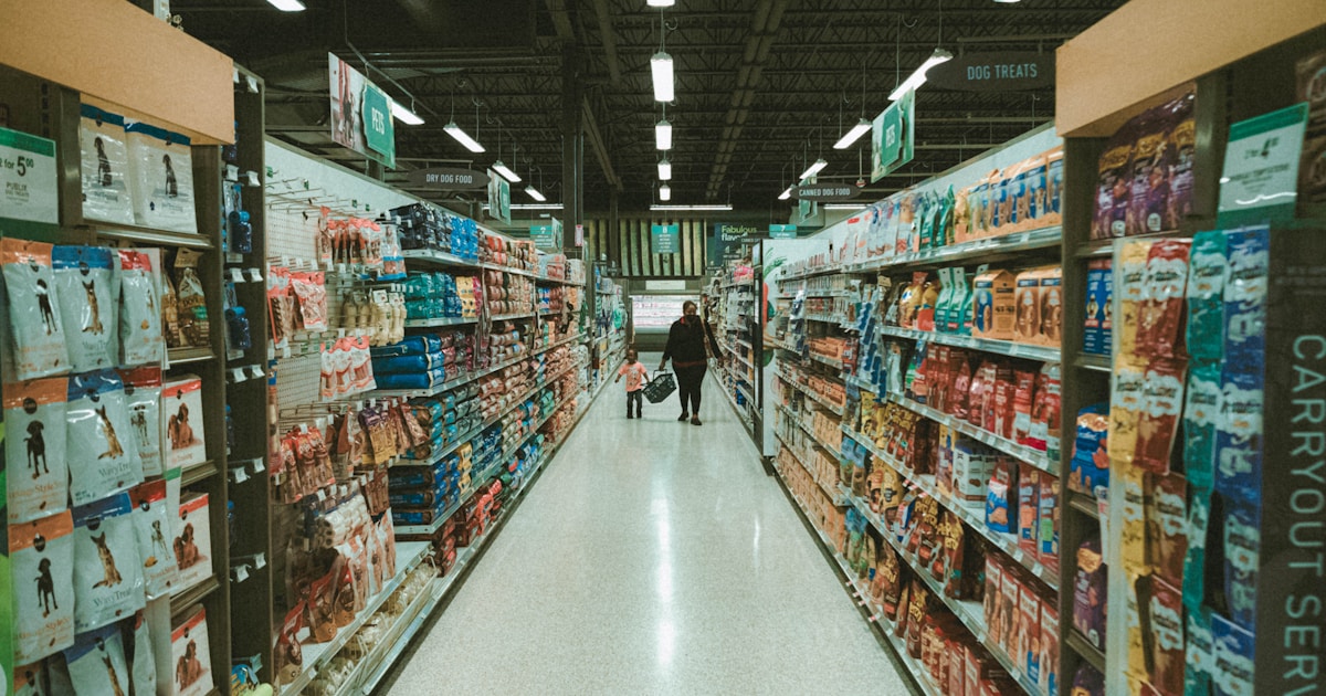 A person walking down an aisle in a grocery store